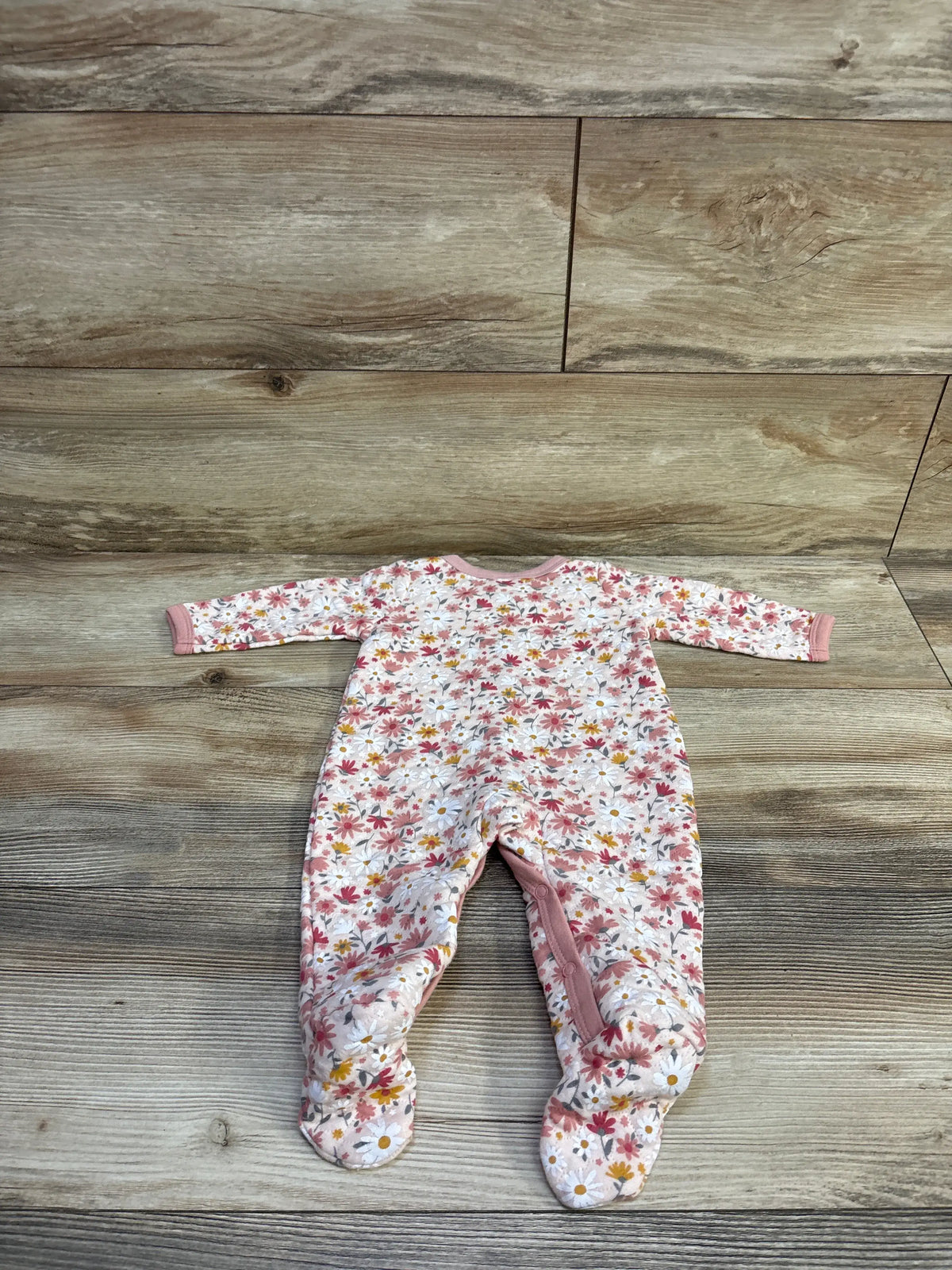 Little Beginnings pink floral quilted baby sleeper for 3-6 months on a wood background