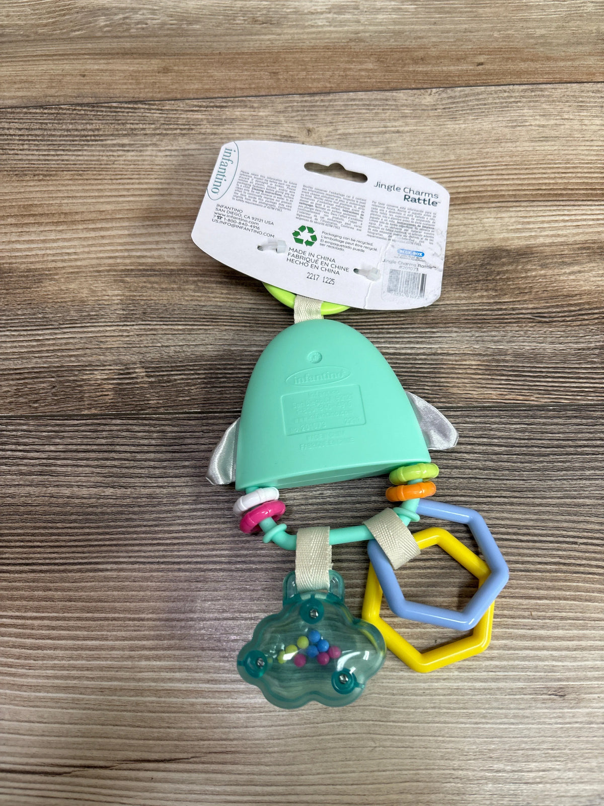 New Me n Mommy To Be Infantino Jingle Charms Rattle Toy for infants on a wooden surface