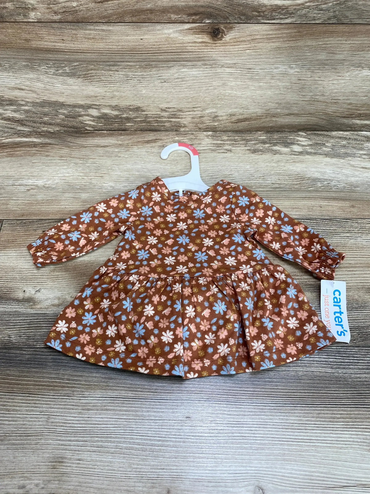 Front view of newborn brown floral dress and matching bloomers showing ruffled sleeves and elastic waist on white background