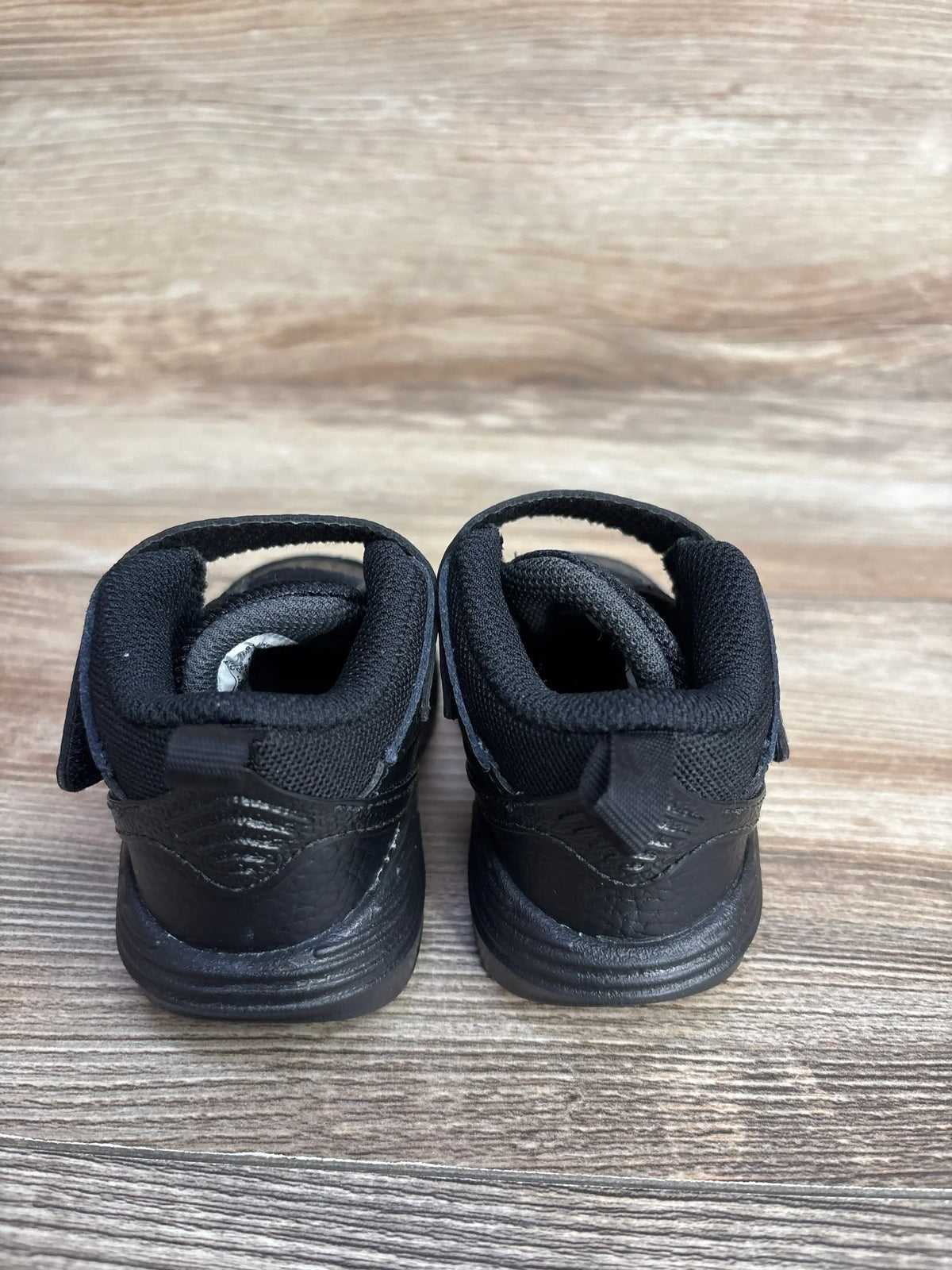 Rear view of Air Jordan Max Aura 5 TD toddler sneakers in Black Anthracite, size 4C, showcasing the heel design on a wood floor