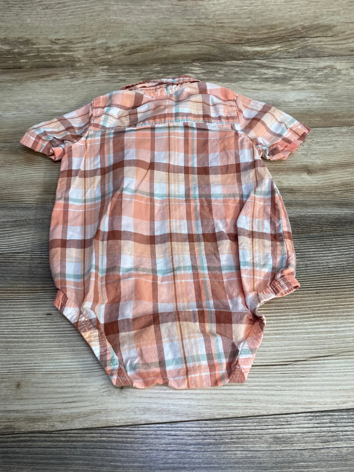 Front view of Oshkosh pink plaid button-up bodysuit, size 18 months, showing collar, buttons and snap bottom on white background