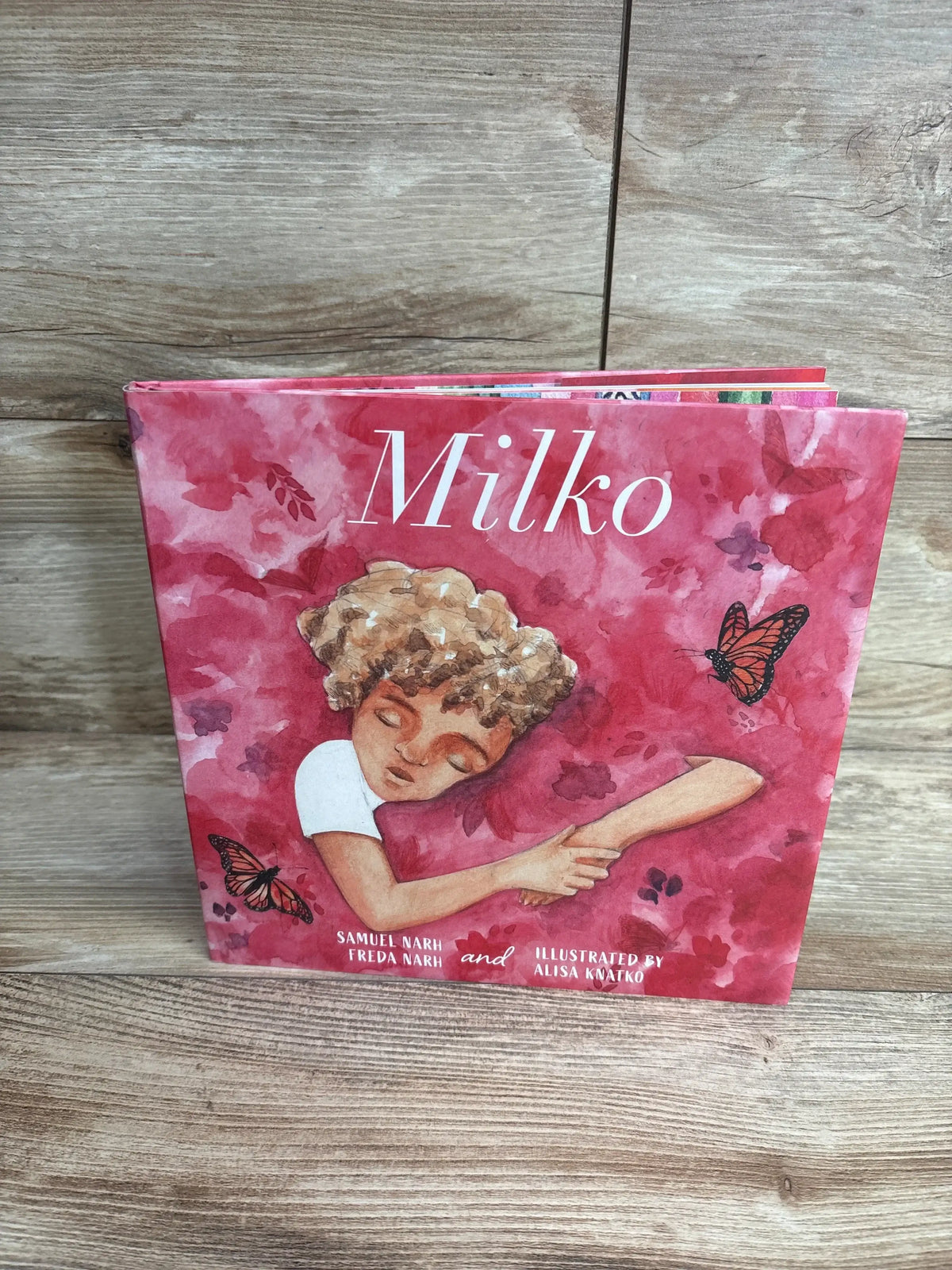 Children's book Milko with illustrated child sleeping and butterflies on pink cover