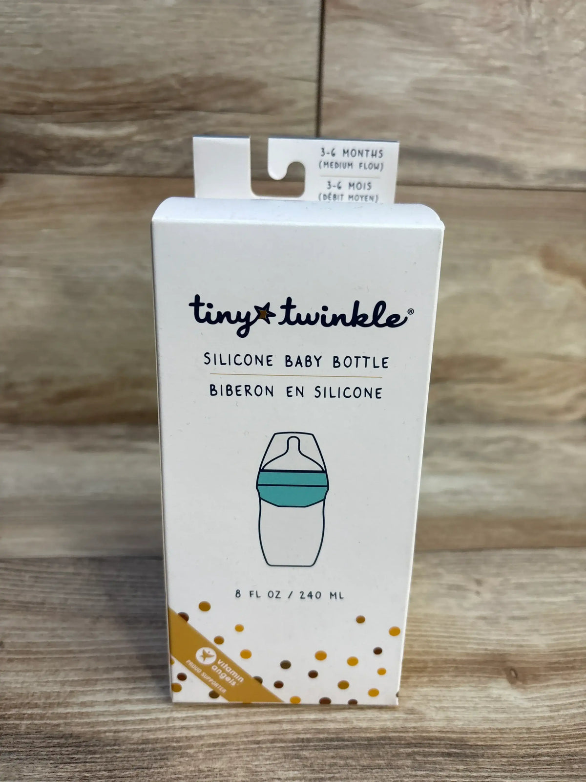 Front view of Tiny Twinkle silicone baby bottle 8 fl oz box in white with 3-6 months medium flow label on wood plank floor