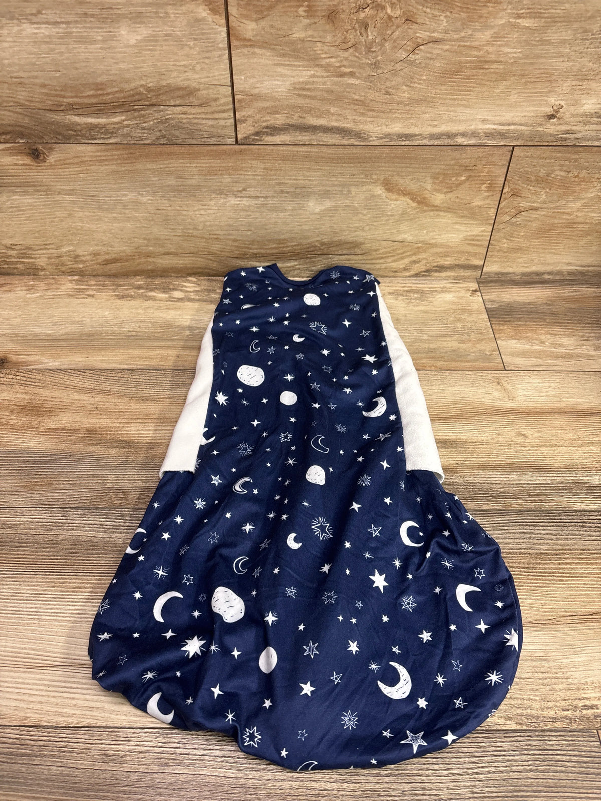 BSTOPPT navy blue sleep sack swaddle with white moon and star print on wood background