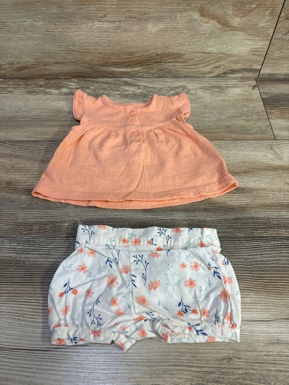 Front view of coral Just One You peplum top and shorts set, size 3 months, with three-button placket and floral pull-on shorts