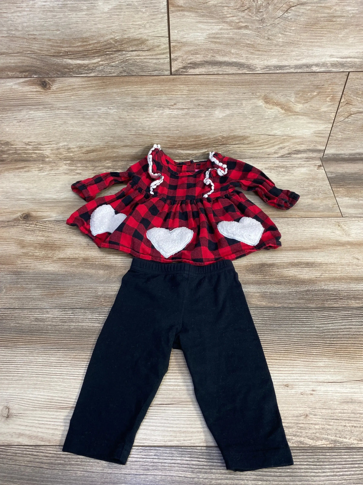 Red plaid dress with white hearts and black leggings on wood background