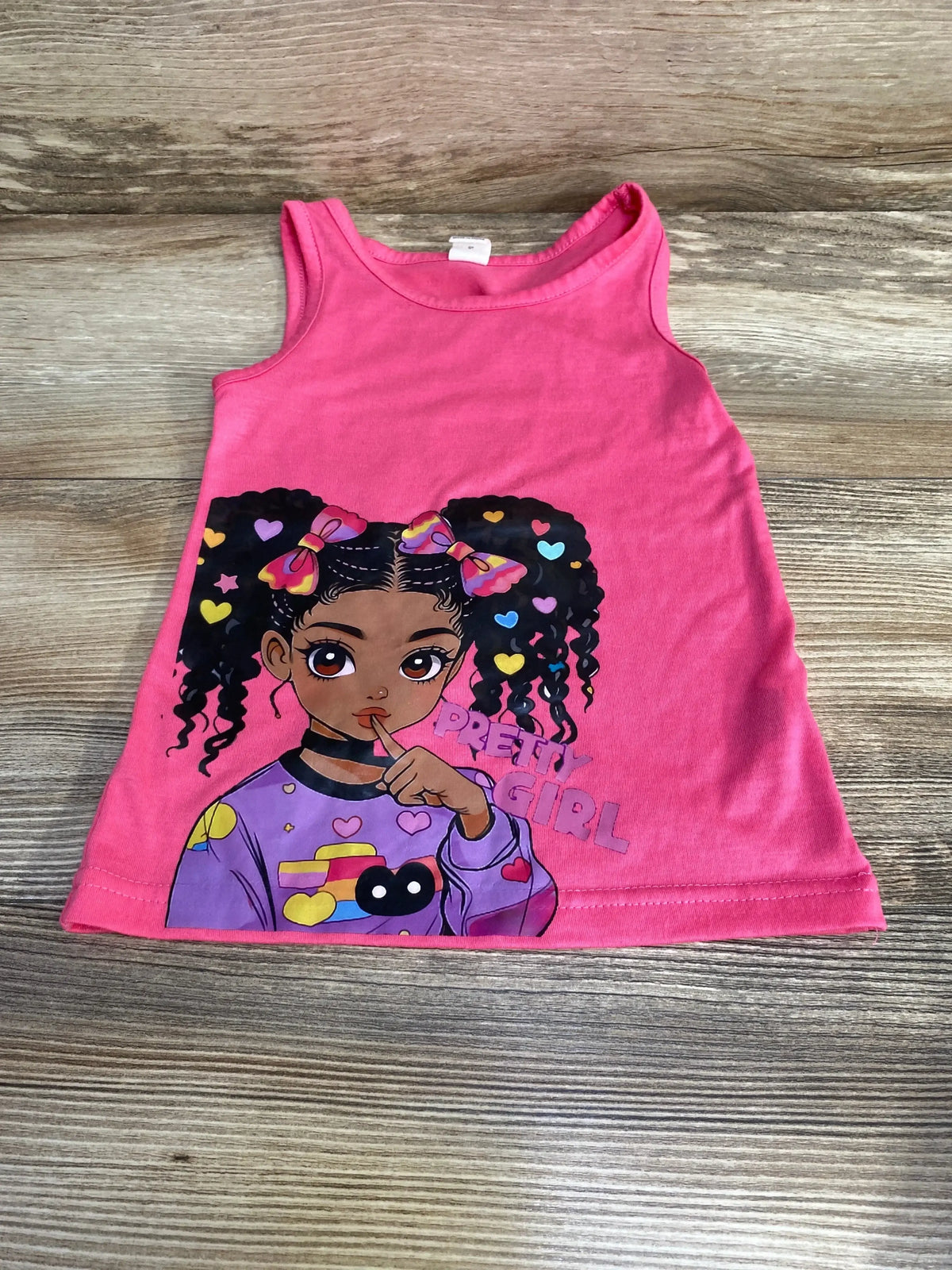 Front flat lay of pink baby tank dress size 6-9 months showing a cartoon girl graphic and the words Pretty Girl on a wood background