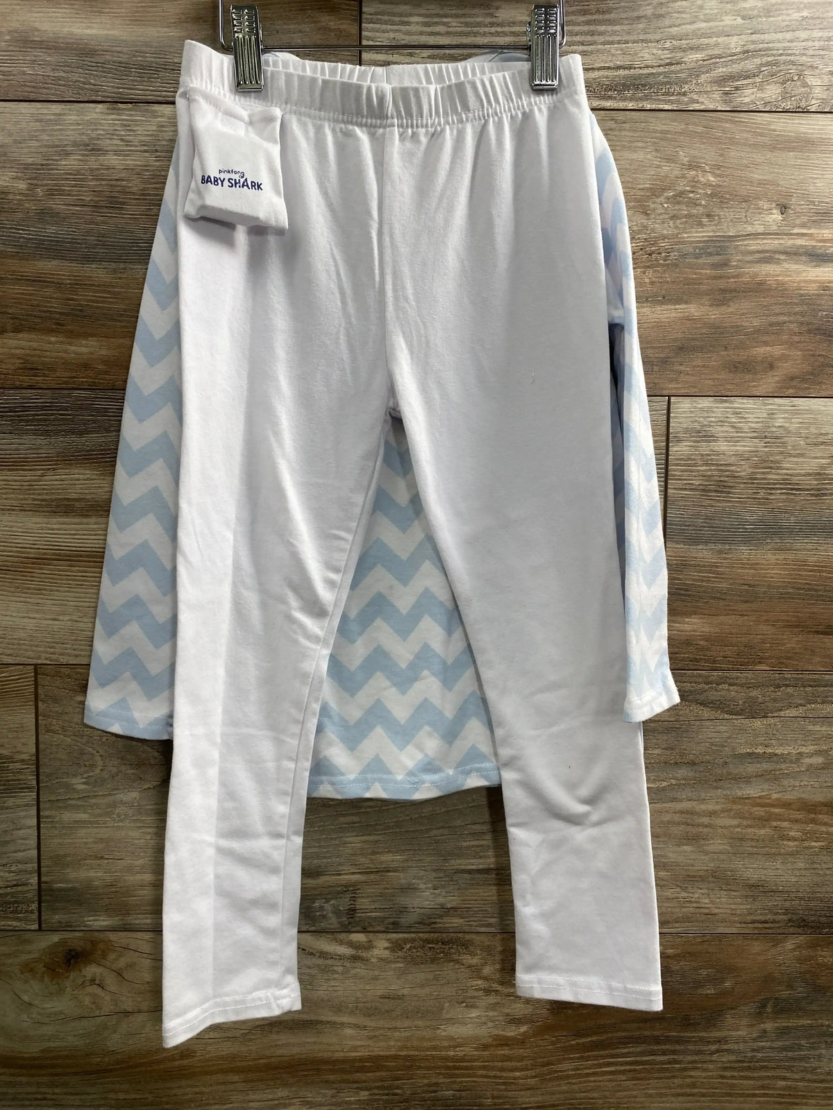 View of Pinkfong Blue Baby Shark costume showing white leggings and blue chevron fabric on a wood background