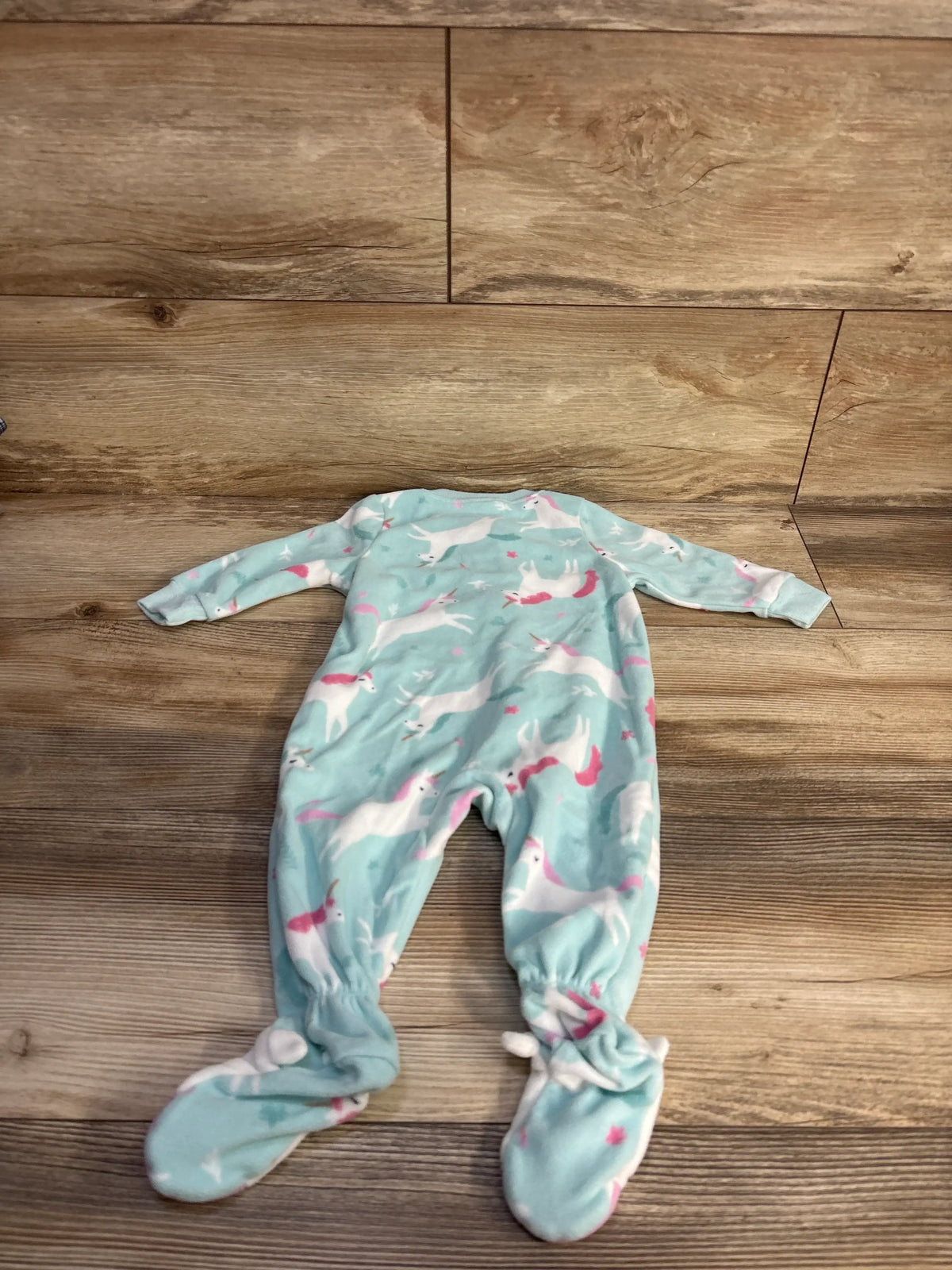 Front view of Carter’s unicorn blanket sleeper showcasing full-body coverage and unicorn print on a wood floor
