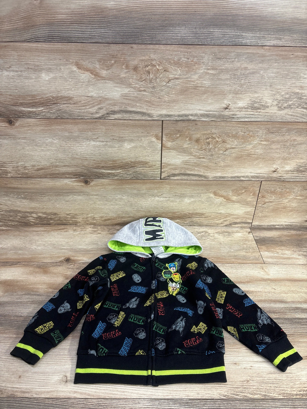 Kids Marvel superhero zip-up hoodie with characters and colorful text, wooden background