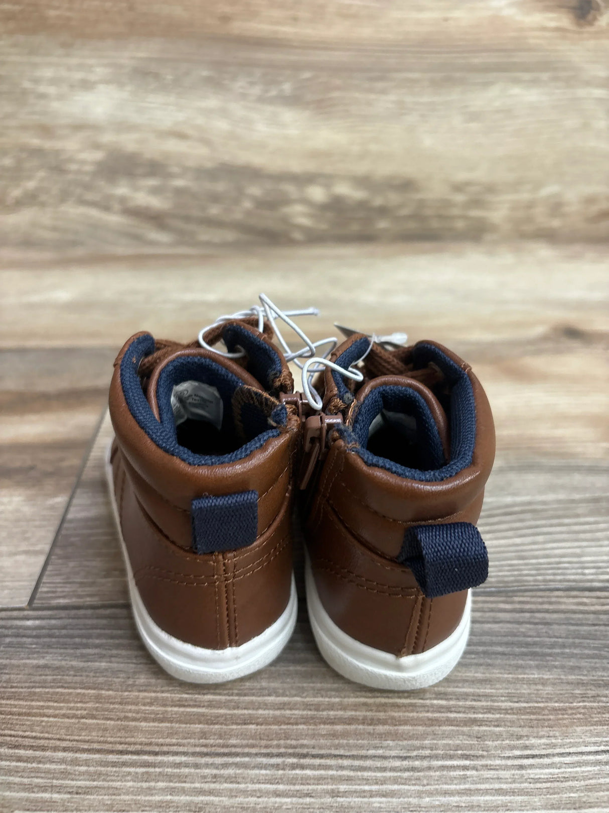 Back view of brown Cat & Jack Mateo high-top sneakers showing navy trim and white soles on a wooden floor