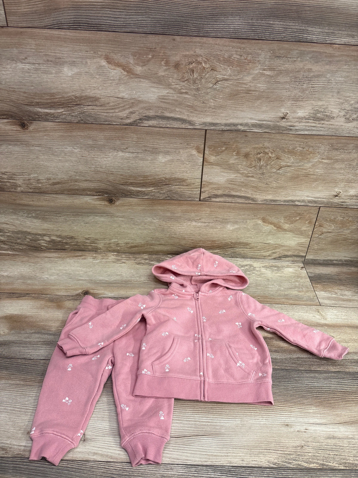 Oshkosh pink 2-piece baby set with full zip hooded jacket and matching pants on wood background