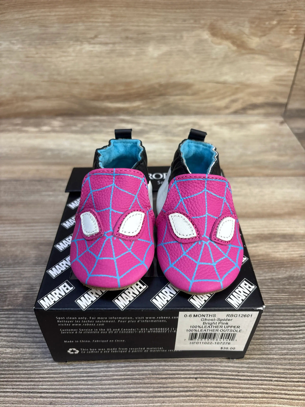 Bright pink Spider-Man baby shoes with blue web design, 0-6 months, leather, on Marvel box