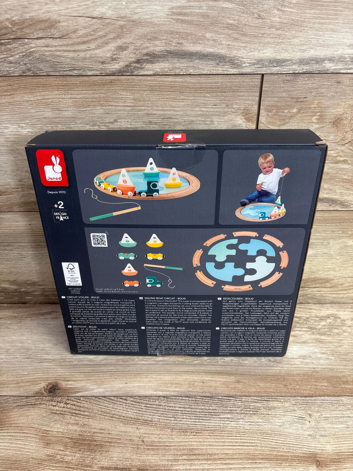 Back of Janod sailing boat circuit toy box showing wooden boats and fishing rod for kids age 2+