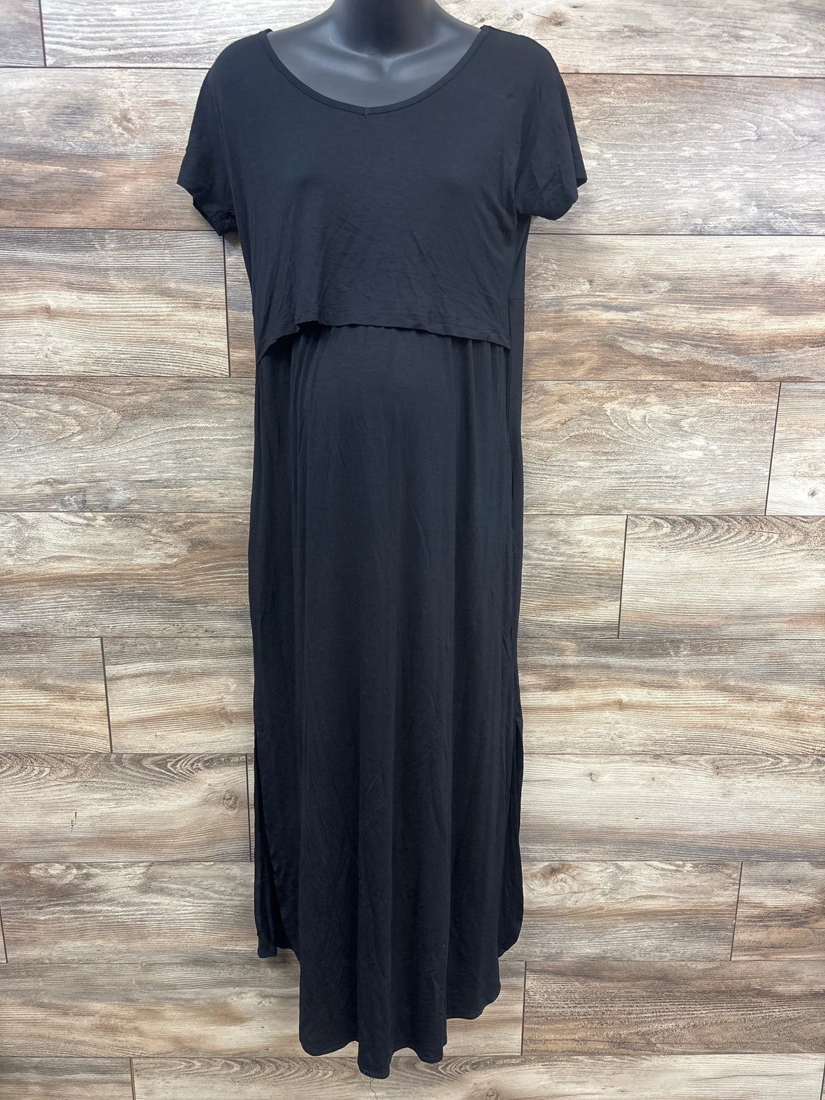 Front view of Smallshow black maternity nursing dress showcasing short sleeves and layered nursing panel against a wood plank background