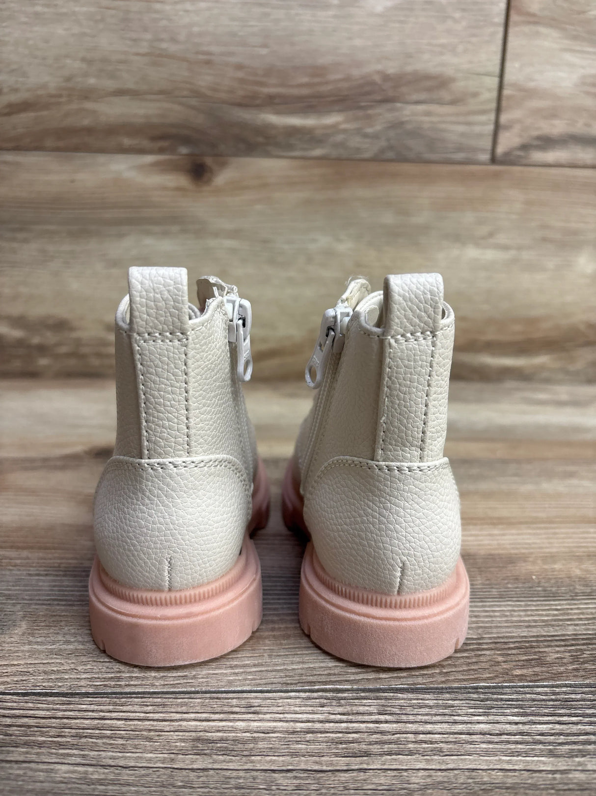 Back view of Cat and Jack Amaya Lace-Up Combat Boots in blush showcasing pebbled cream upper side zipper and pink lug sole on wood plank floor