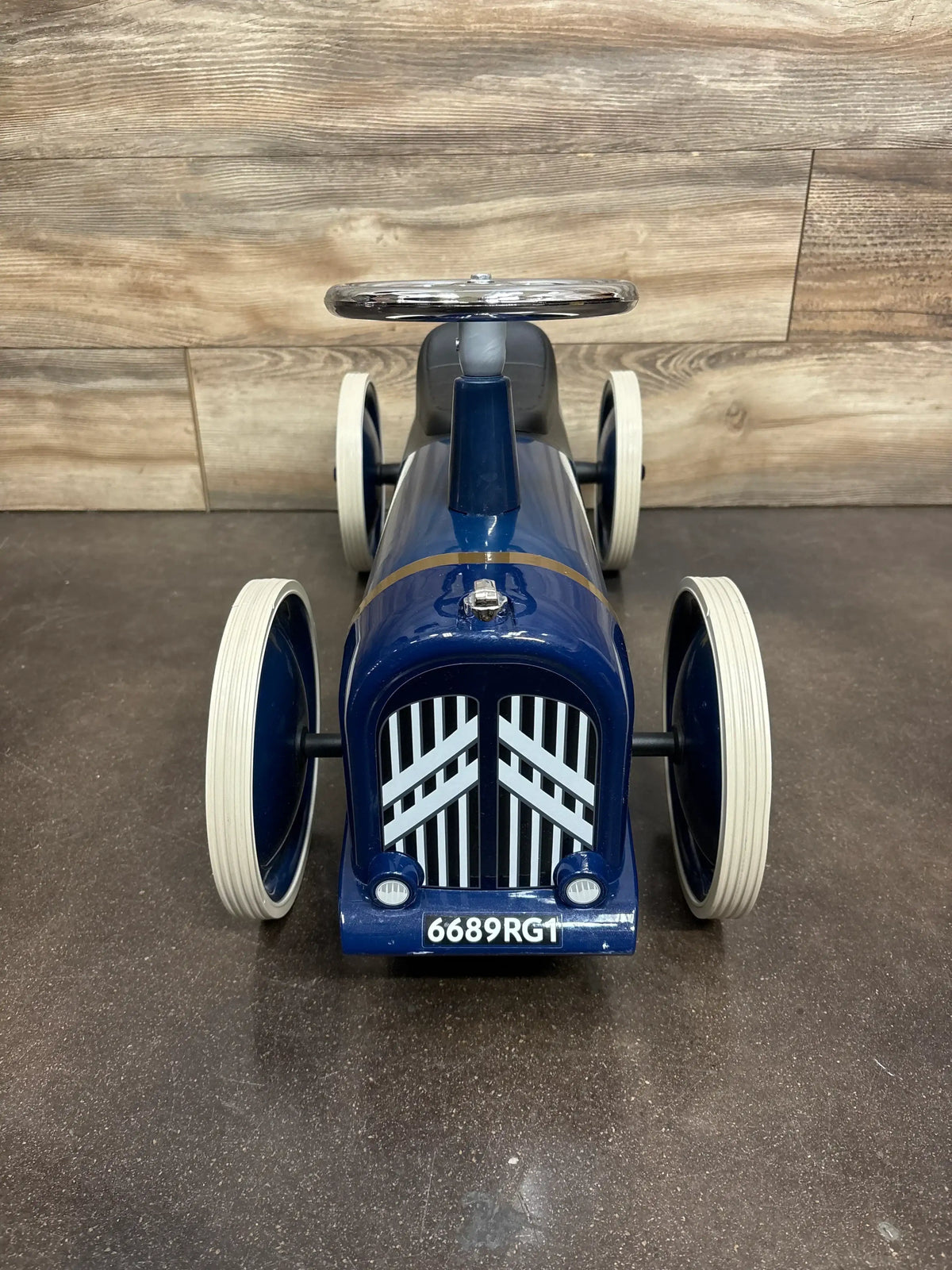 Front view of Baghera Speedster Rosalie Citroen ride-on showing glossy blue finish, white tires, and grille on dark floor