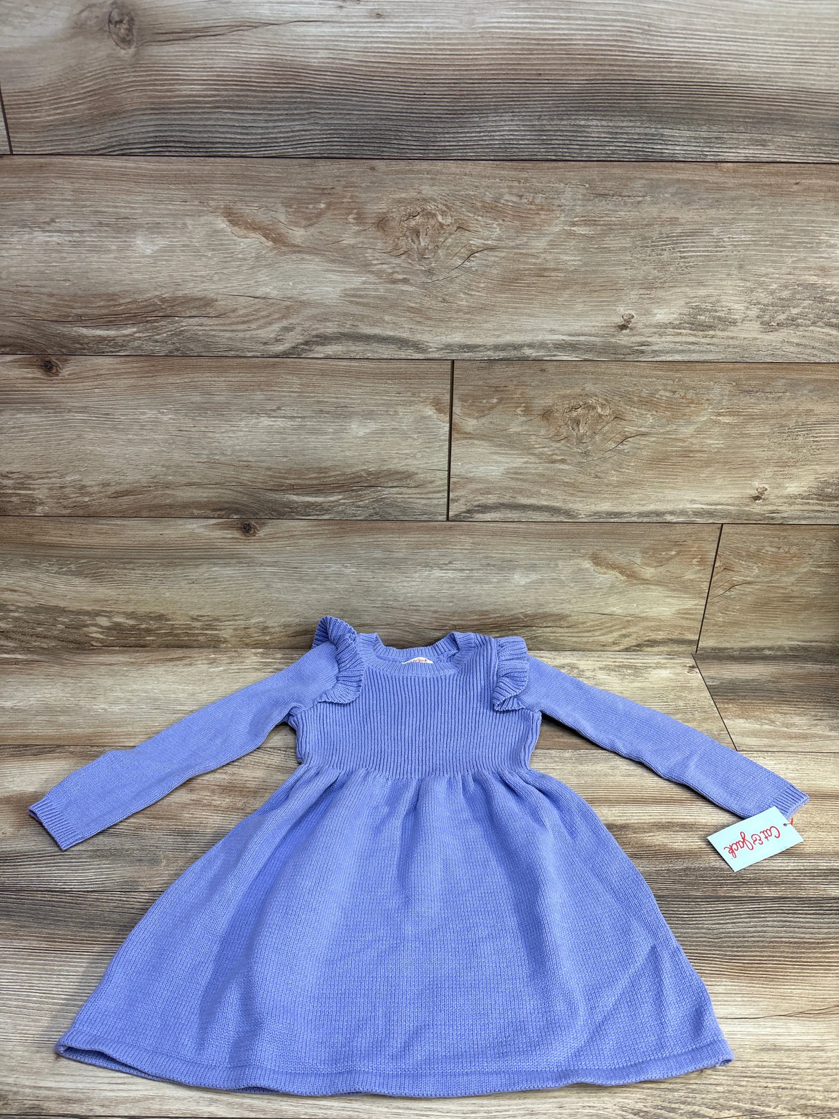 Flat lay of purple Cat and Jack knit toddler dress size 4T with ribbed bodice, ruffled shoulders on wood background