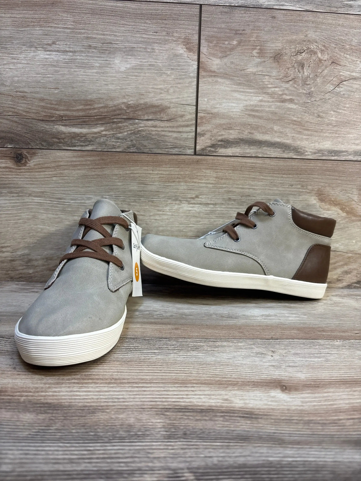 Angled front view of Cat and Jack Jakob gray high-top kids’ boots with brown laces and white soles on wood floor, size 5Y tag visible