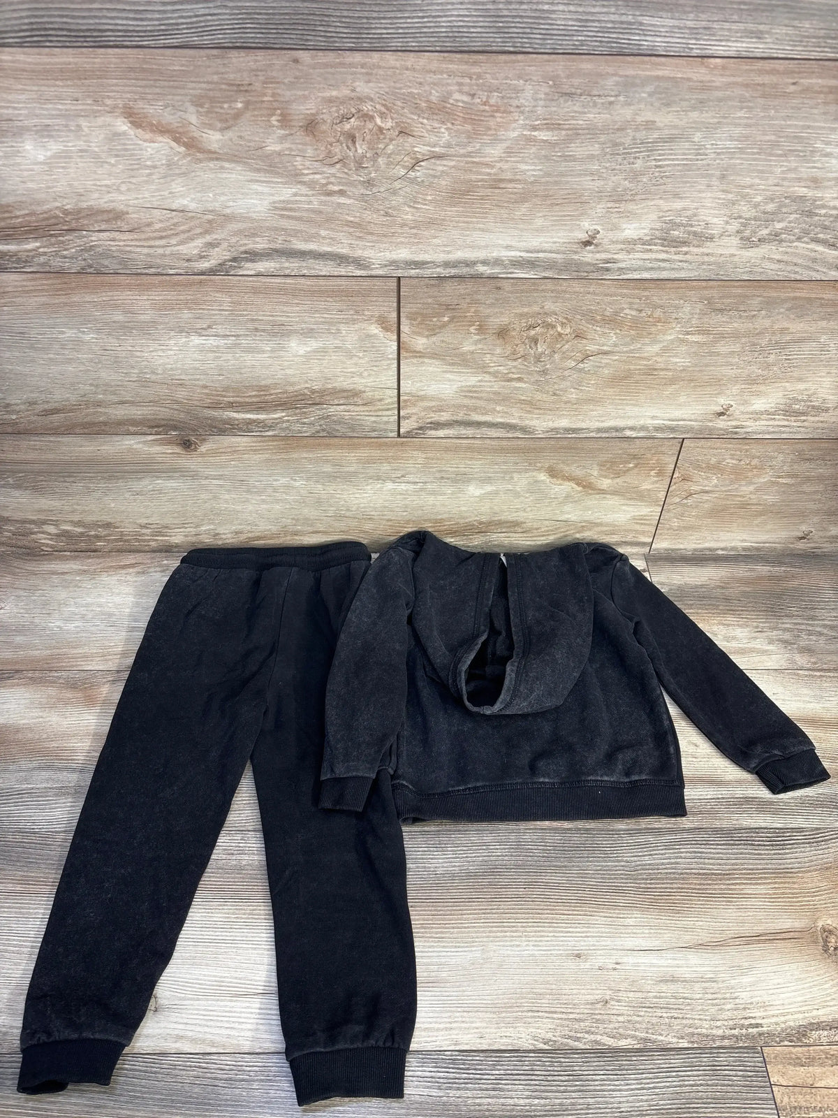 Flat lay of grey Rolling Stones sweatshirt and joggers size 4T showing hood and elastic cuffs on wood floor
