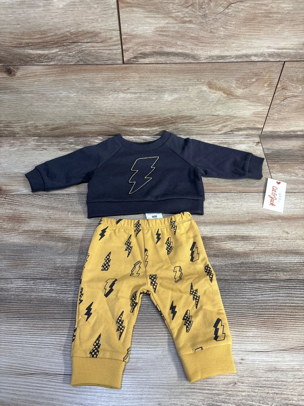 Front view of Cat & Jack 2pc set showcasing dark gray lightning sweatshirt and mustard-yellow patterned joggers