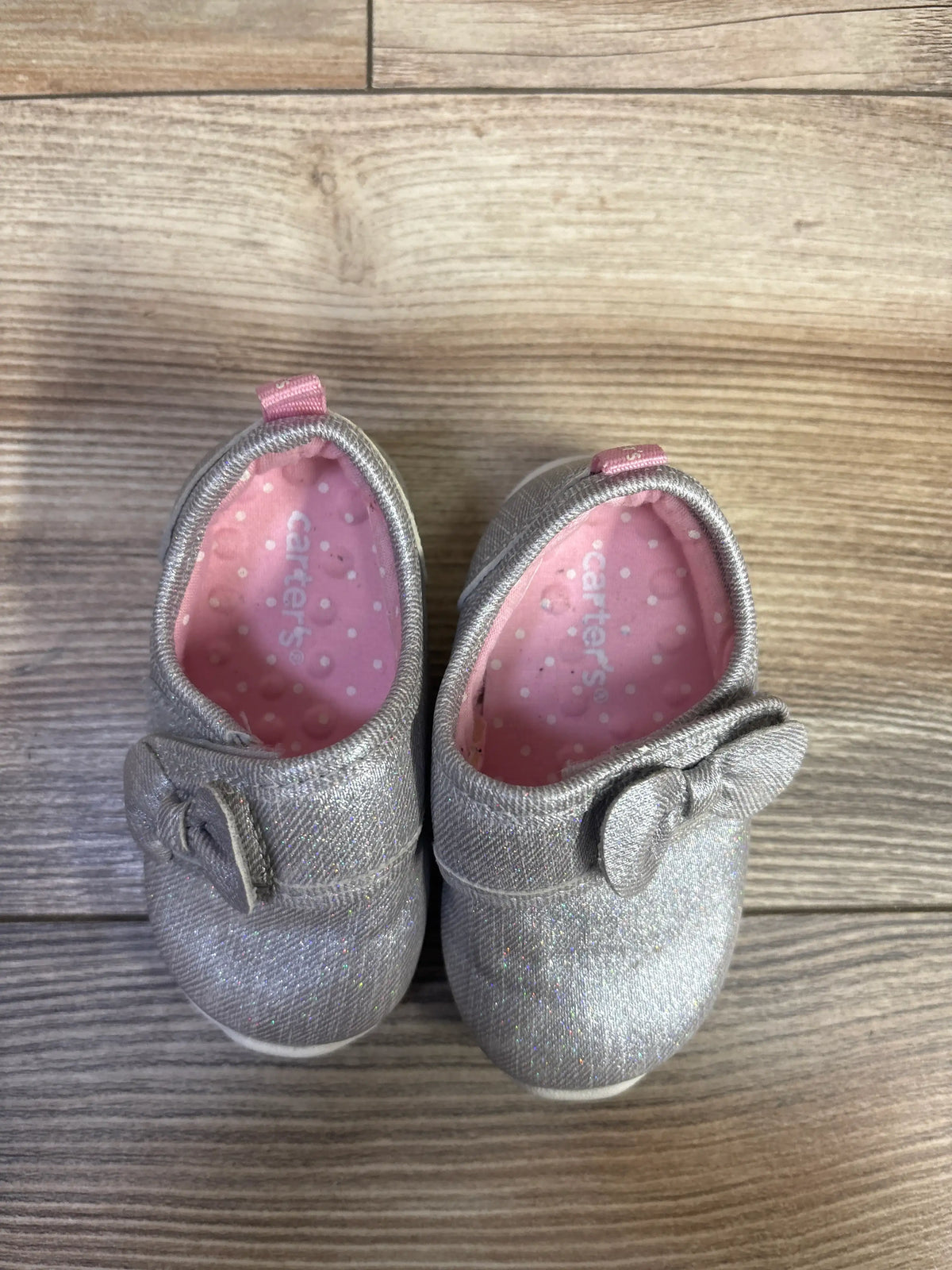 Top view of Carter’s Every Step walking shoes showing grey glitter uppers, bows, and pink polka-dot lining