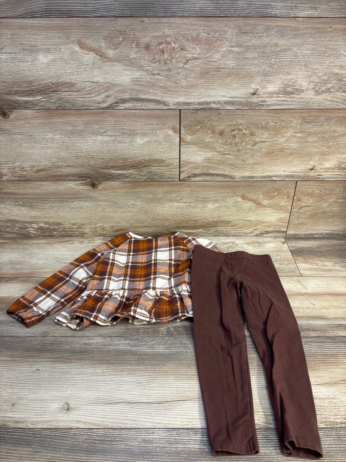 Plaid ruffle top and brown leggings kids outfit on wood floor