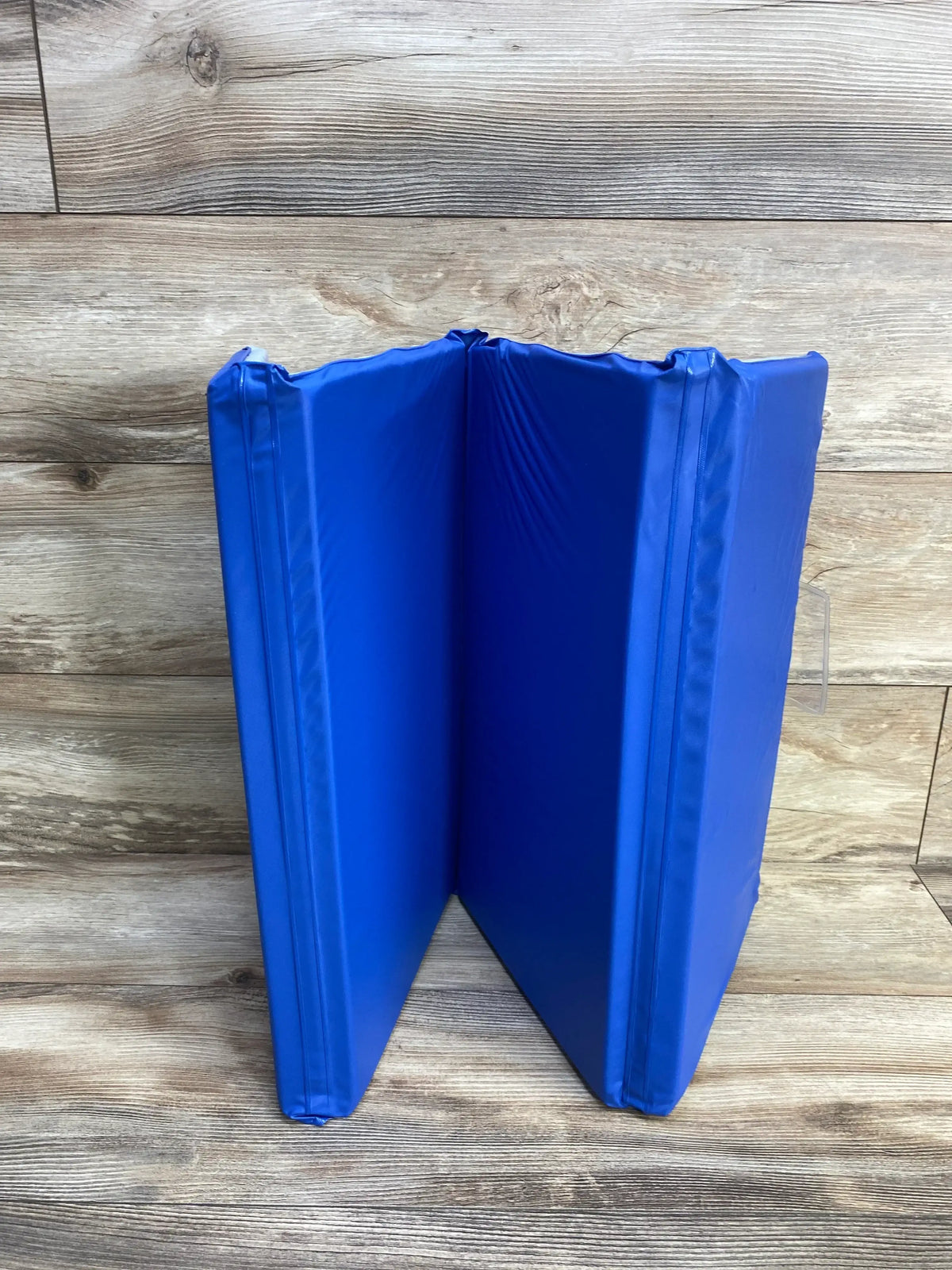 Folded view of ProSource Four-Fold Kids Rest Nap Mat showcasing blue vinyl covering with a wood-look background