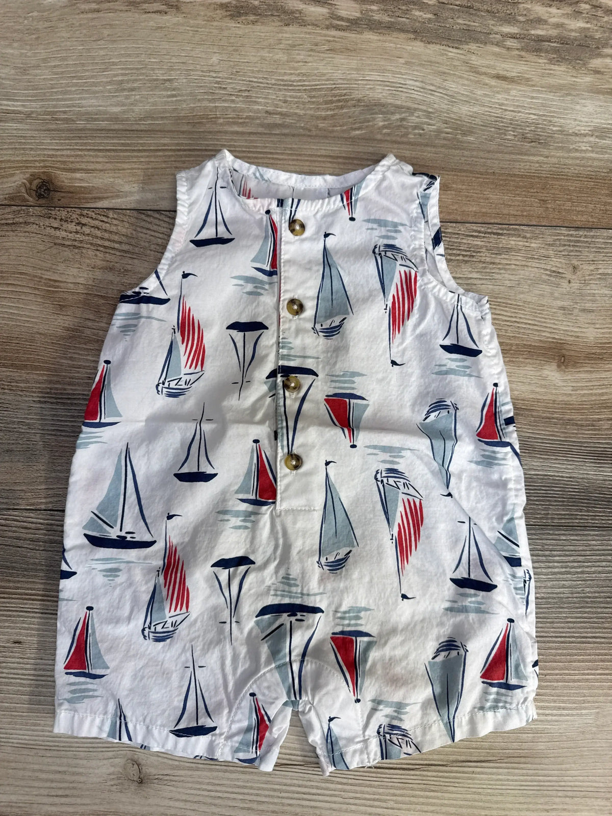 Front view of Just One You sailboat tank romper, size 3 months, showcasing sailboat print and front buttons on a wood background