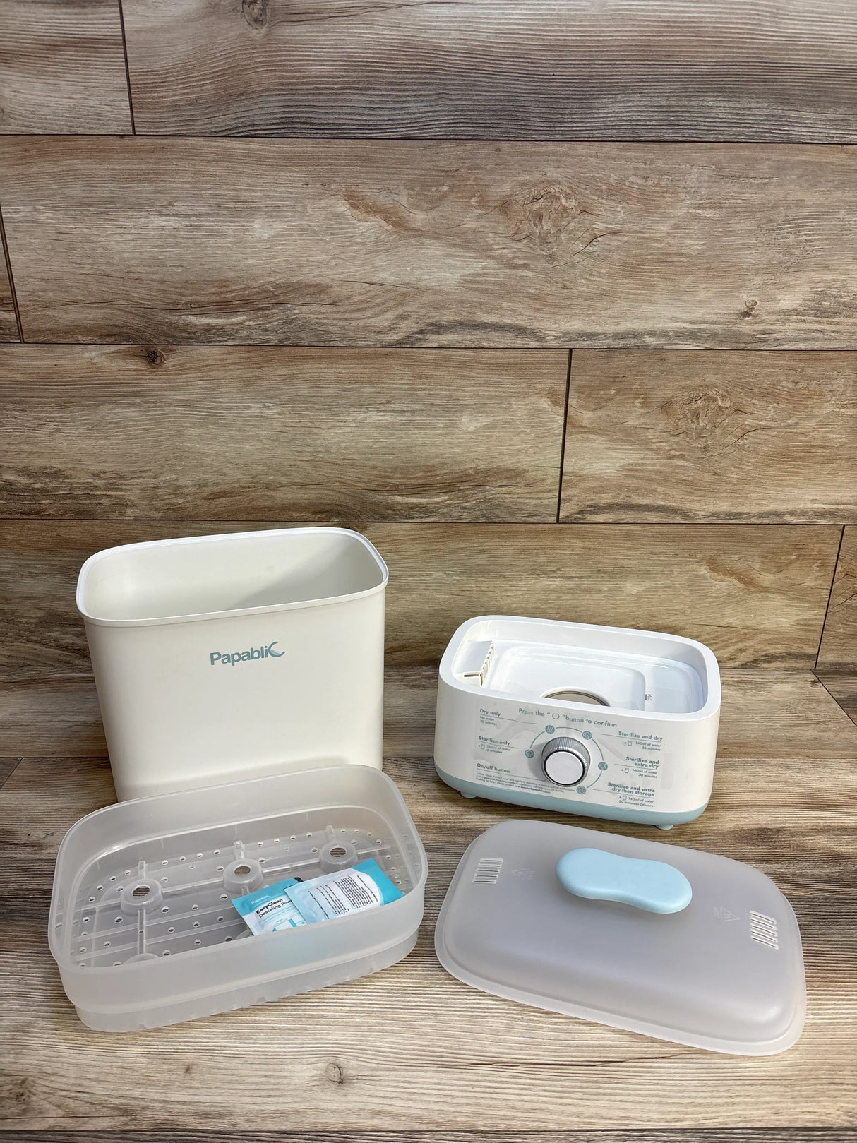 Papablic baby bottle sterilizer and dryer parts on wooden surface, baby gear accessories