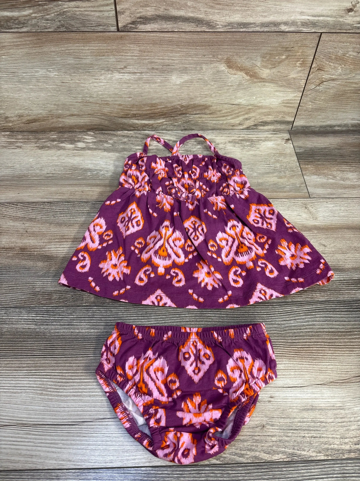 Purple Carter’s dress and bloomers set, overhead view, showing sleeveless tiered dress and elastic bloomers on wood floor