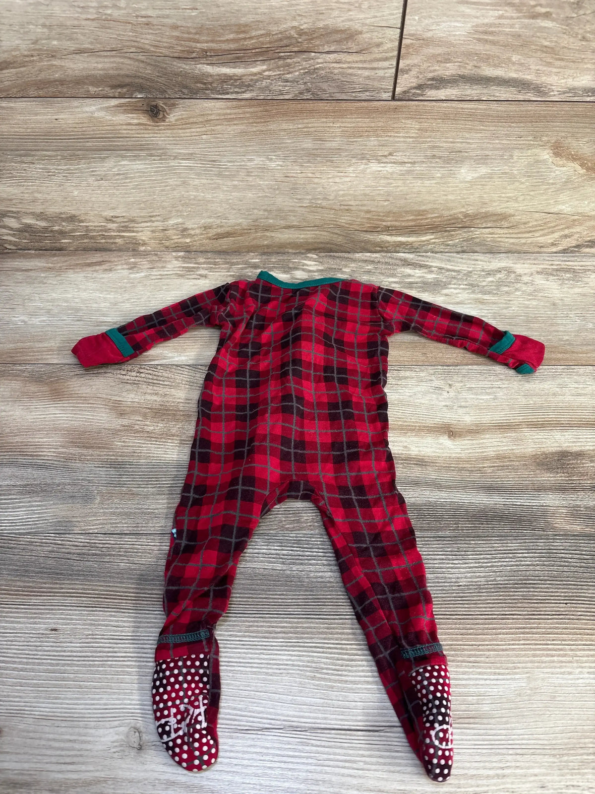 Back view of Kickee Pants red plaid zippered footie with green trim, fold over cuffs and dotted non slip soles on wood floor