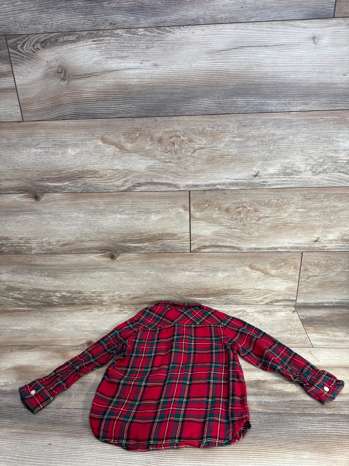 Red plaid long sleeve toddler shirt on wood background, gently used kids clothing
