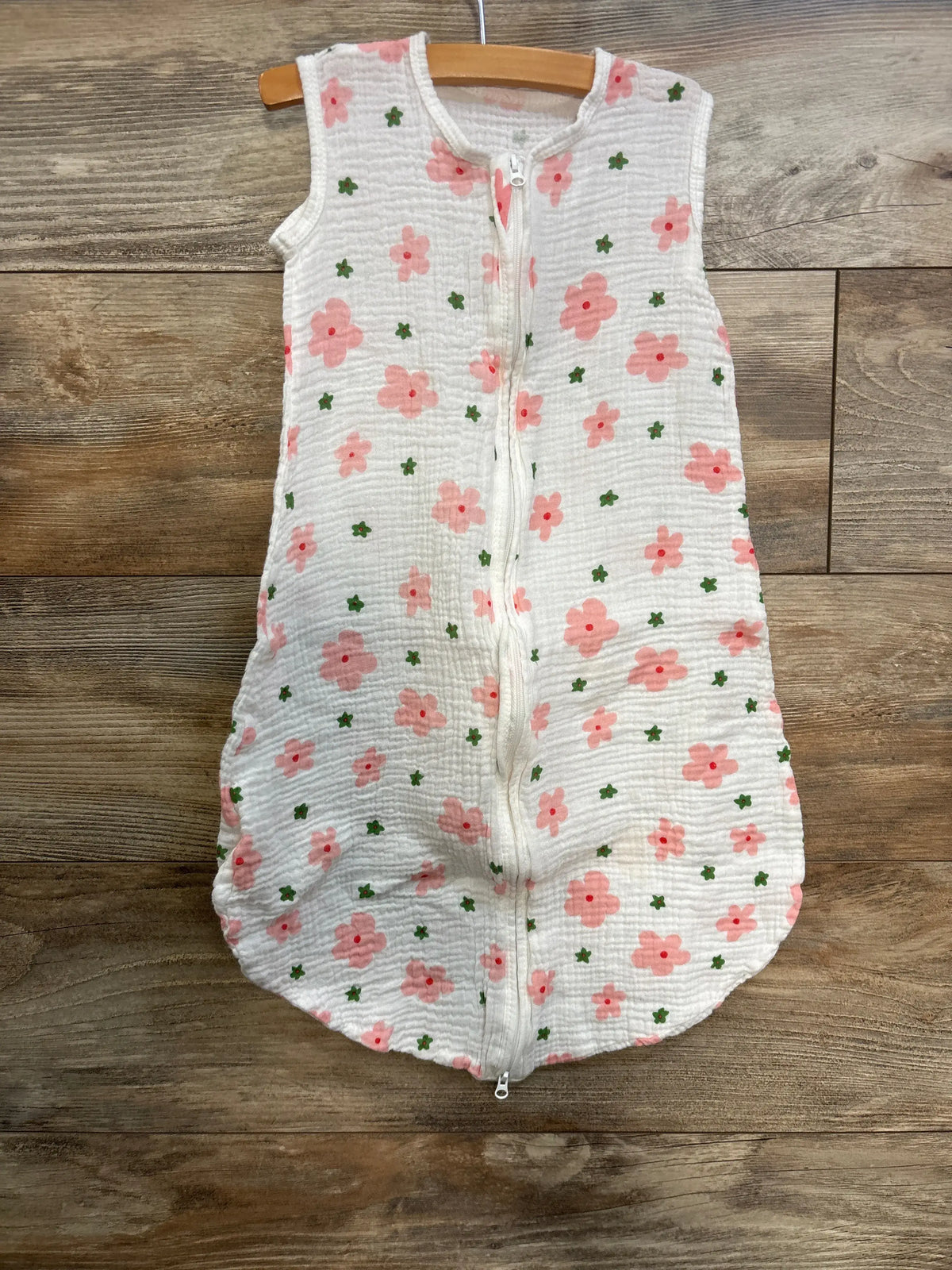 Front view of BSTOPPT gauze sleep sack showcasing white fabric with pink and green floral print and front zipper on a wooden hanger