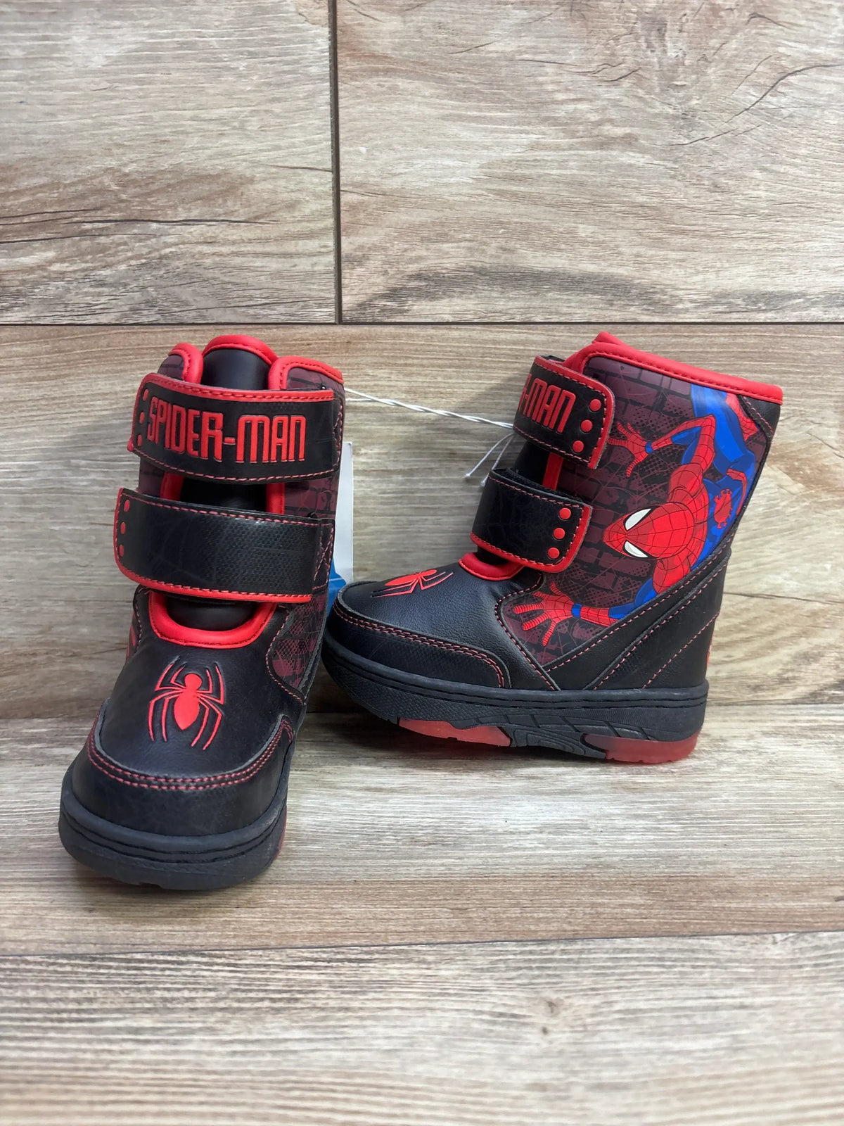 Kids' Spider-Man winter boots, black with red and blue design, Velcro closure, on wood floor