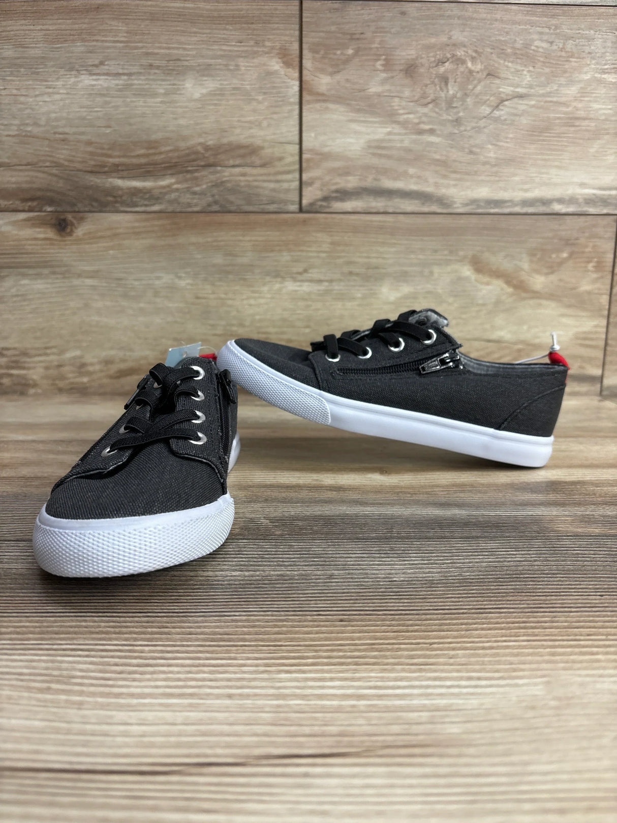 Angled front of Cat and Jack Lucian double zipper kids sneakers in grey with white sole, showing side zipper on wooden floor