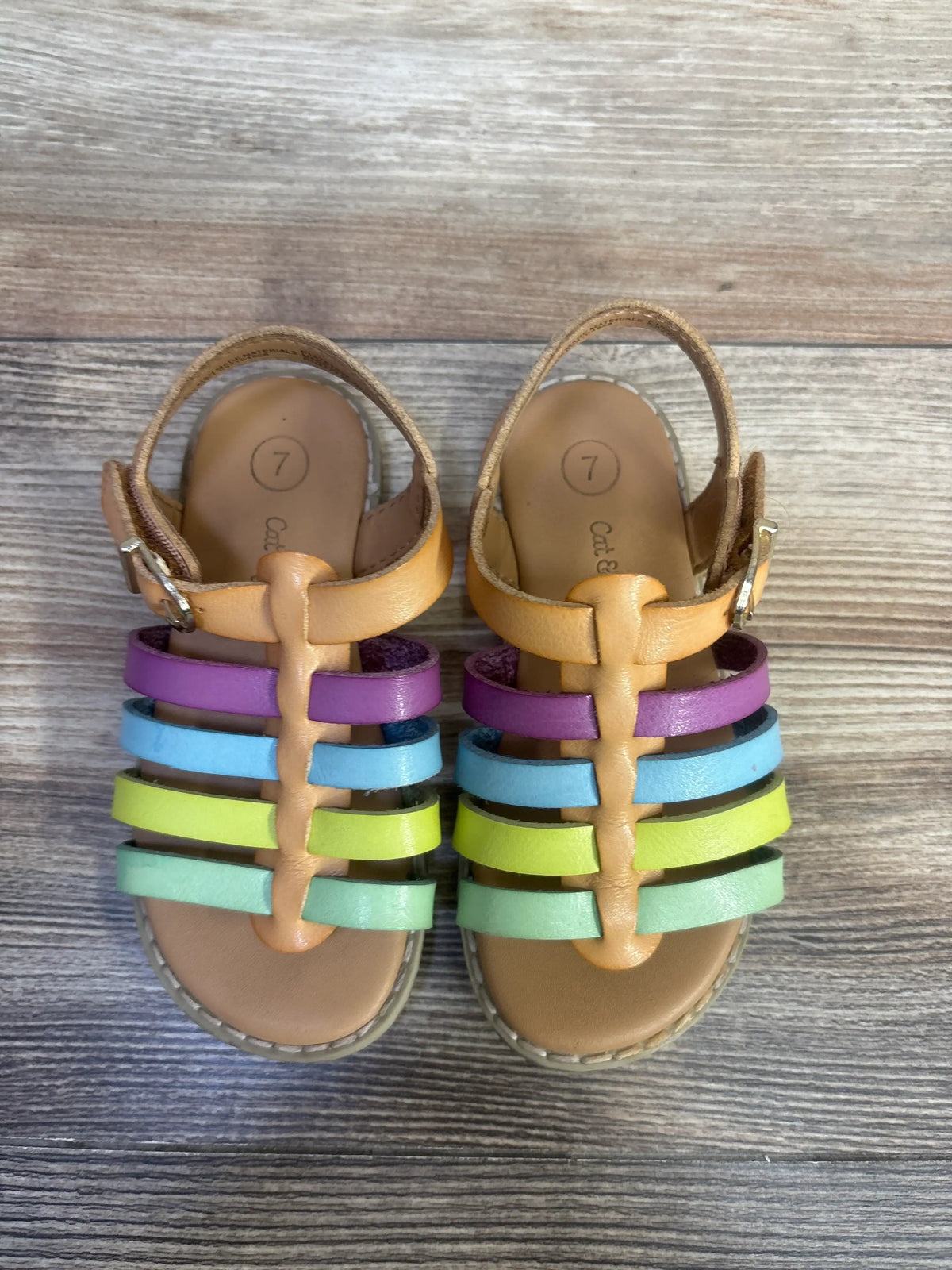 Top view of Cat & Jack Shanel fisherman sandals showcasing multicolored straps and hook and loop closures on a wood surface