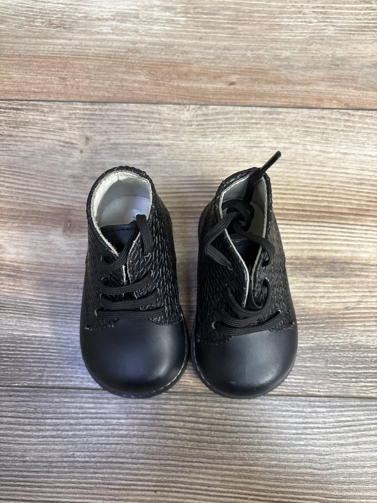 Top view of Josmo First Walker woven oxford baby shoes size 2C showcasing textured sides and laces on light wood floor