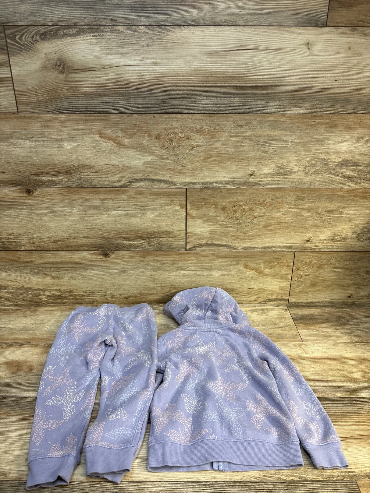 Lavender kids hoodie and joggers set with floral print, laid on wood floor
