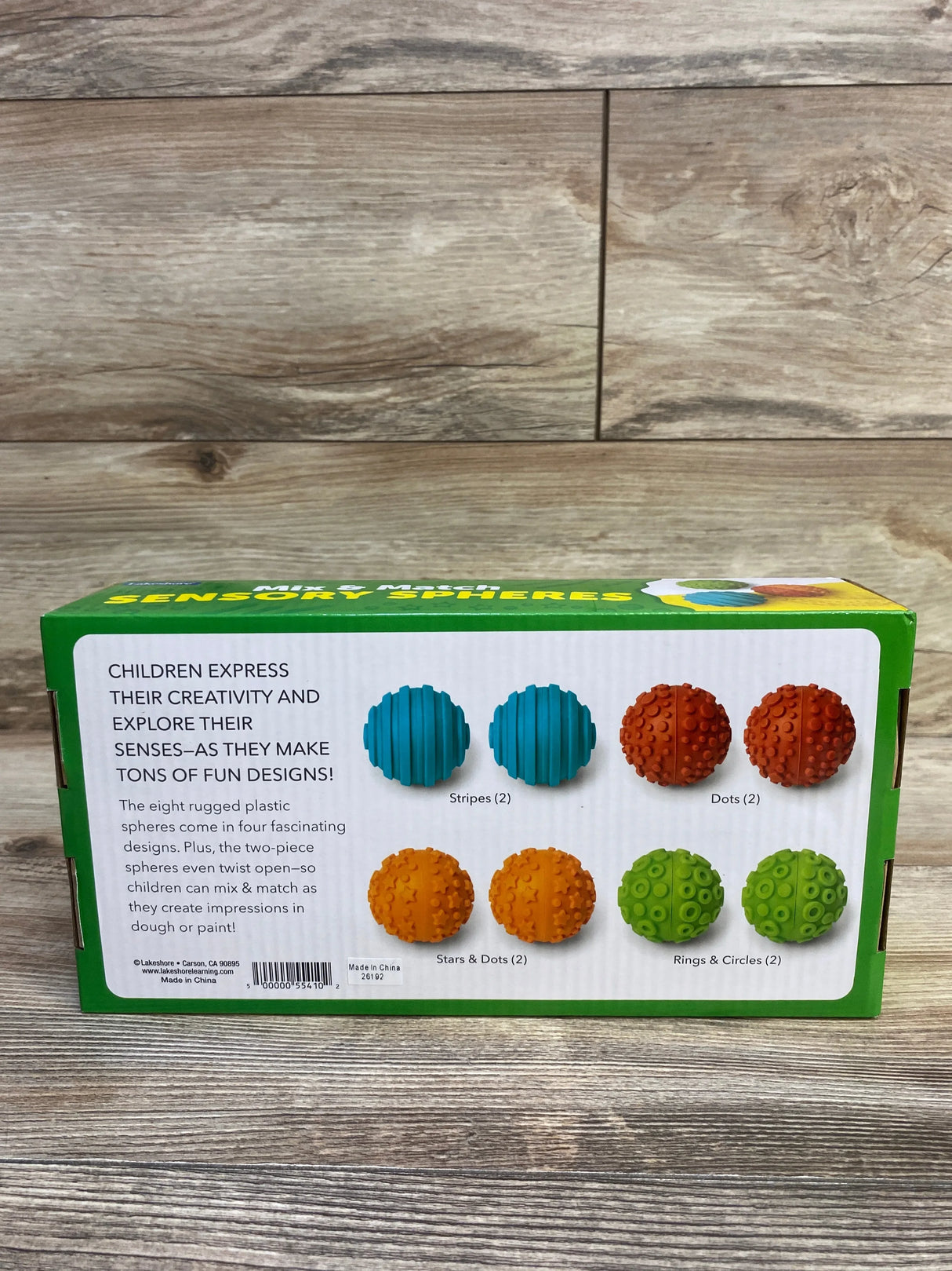 Rear view of Lakeshore Mix and Match Sensory Spheres box showing four pairs of textured spheres on a wood surface