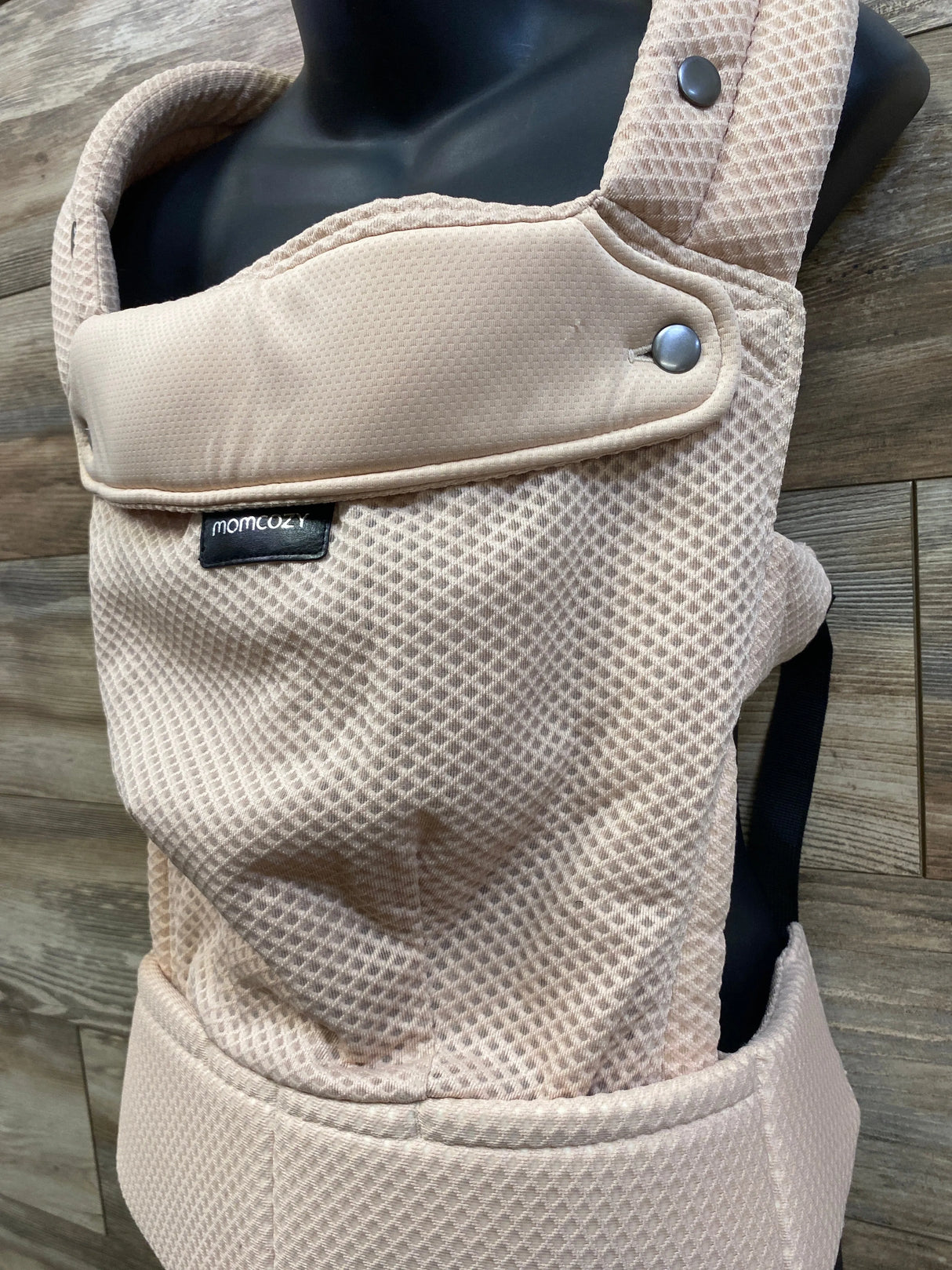 Front close-up of Momcozy PureHug Air Mesh carrier in beige showing breathable mesh, padded straps, snap closures