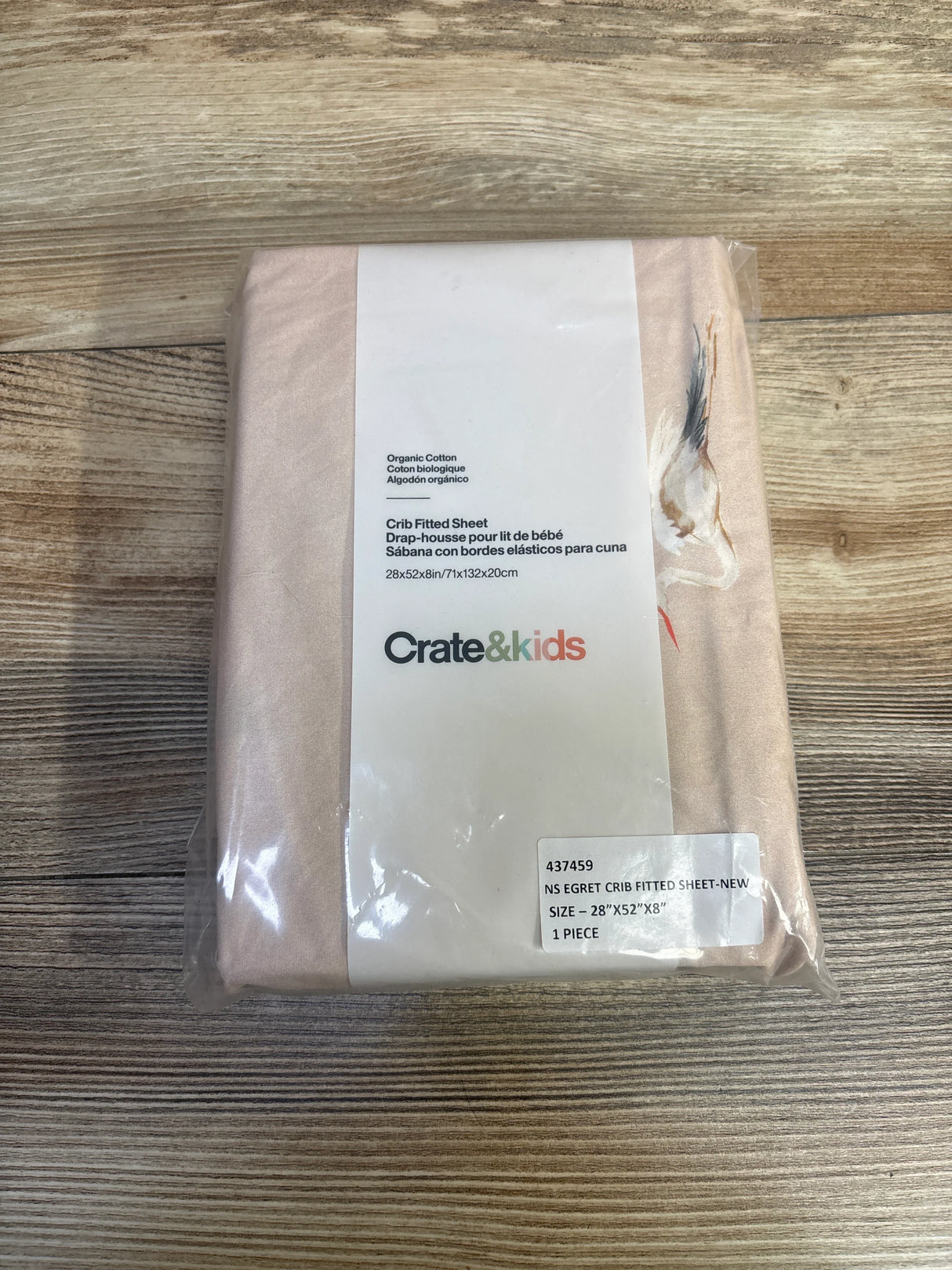 Crate&kids organic cotton crib fitted sheet in beige packaging on wooden surface