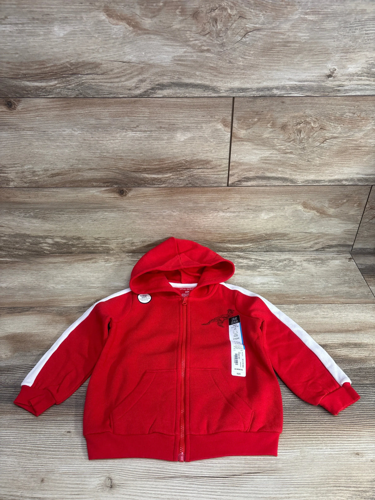 Red toddler hooded zip-up jacket with white sleeve stripes on wooden background
