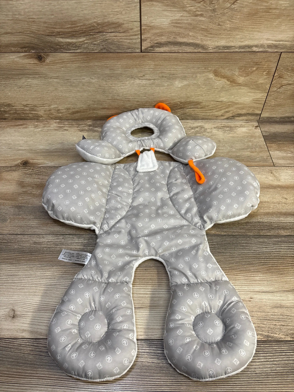 Top view of BenBat grey Total Body Baby Support Pillow showing head, side, and leg supports on a wood floor