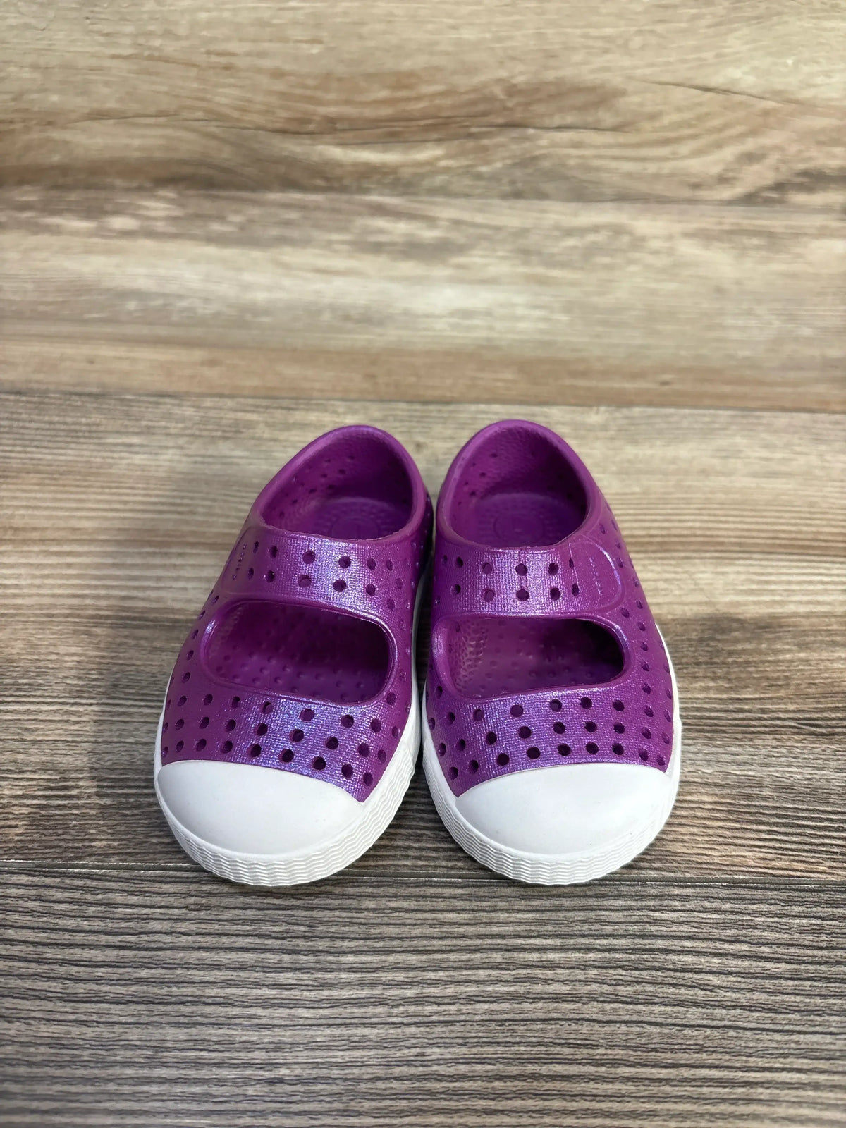 Front view of Native Jefferson toddler shoes size 4C showing purple perforated rubber upper and white toe caps on wood floor
