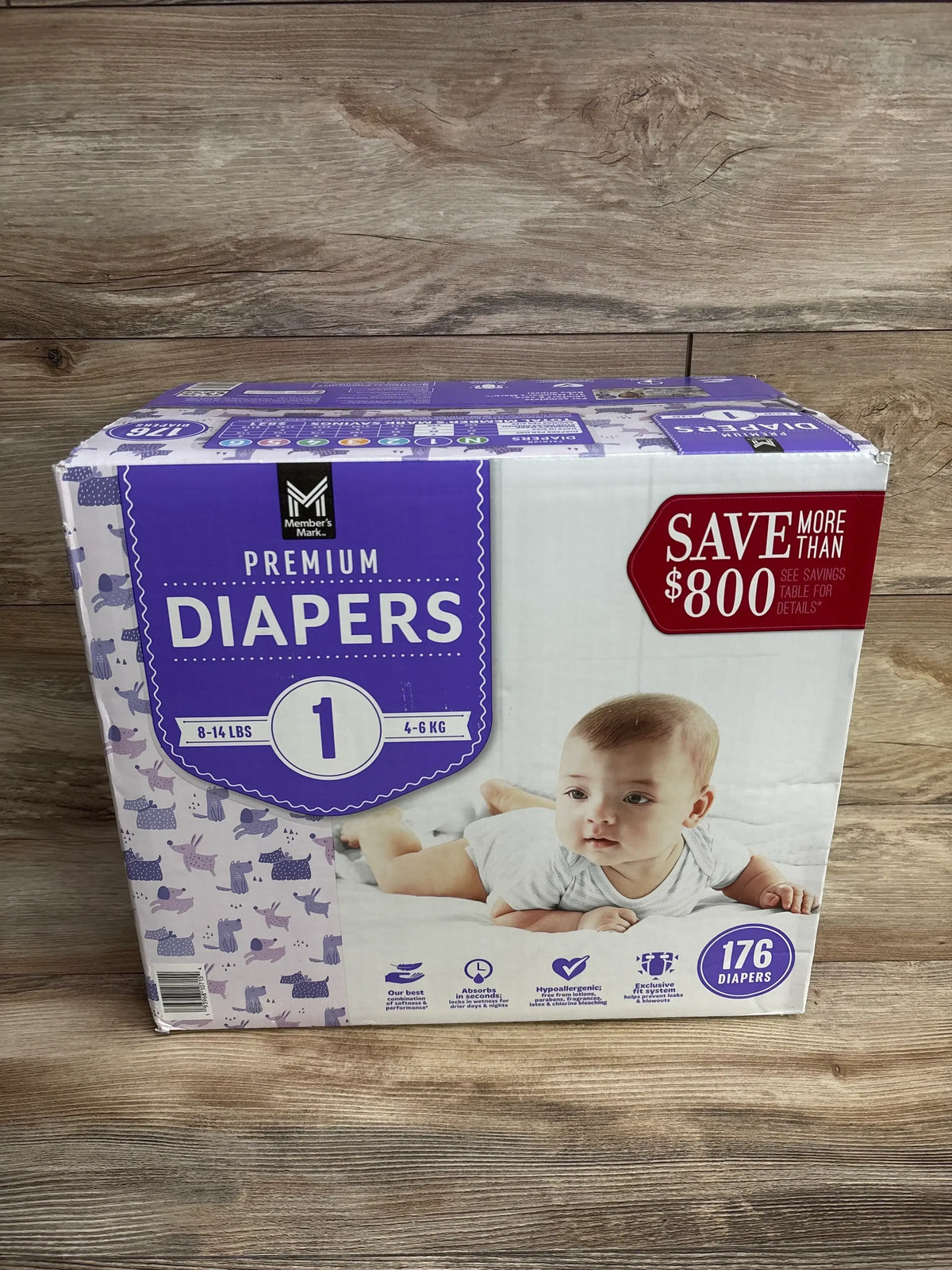 Box of size 1 premium diapers for babies, 8-14 lbs, 176 count, on wooden background