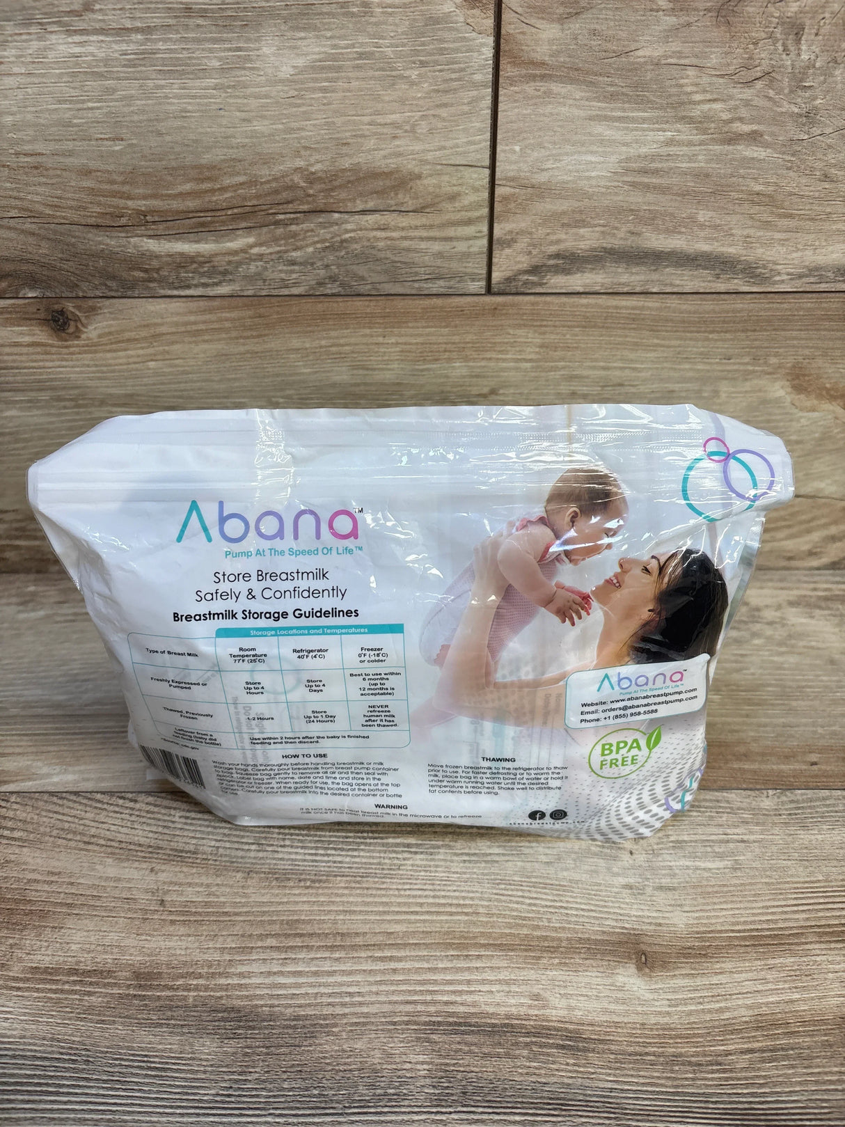 Abana breastmilk storage bags package with mother lifting baby, BPA free, on wood background