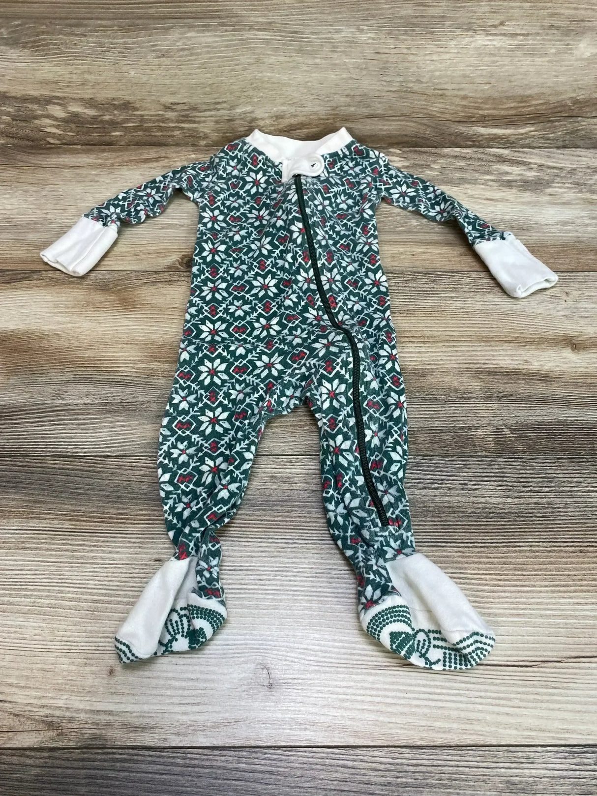Flat lay of Burt’s Bees Baby organic green sleeper (0-3M) showing front zipper, fold-over mittens and gripper feet on wood background