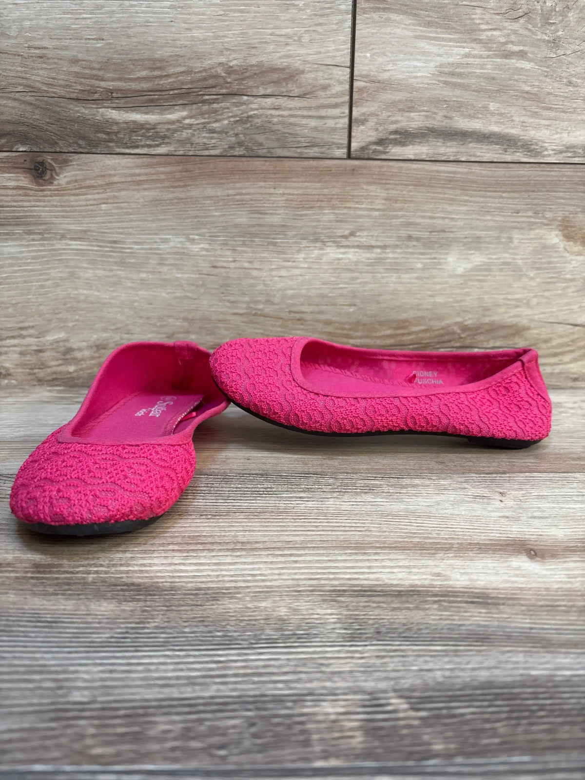 Girls’ bright pink lace ballet flats on wood floor, gently used kids shoes