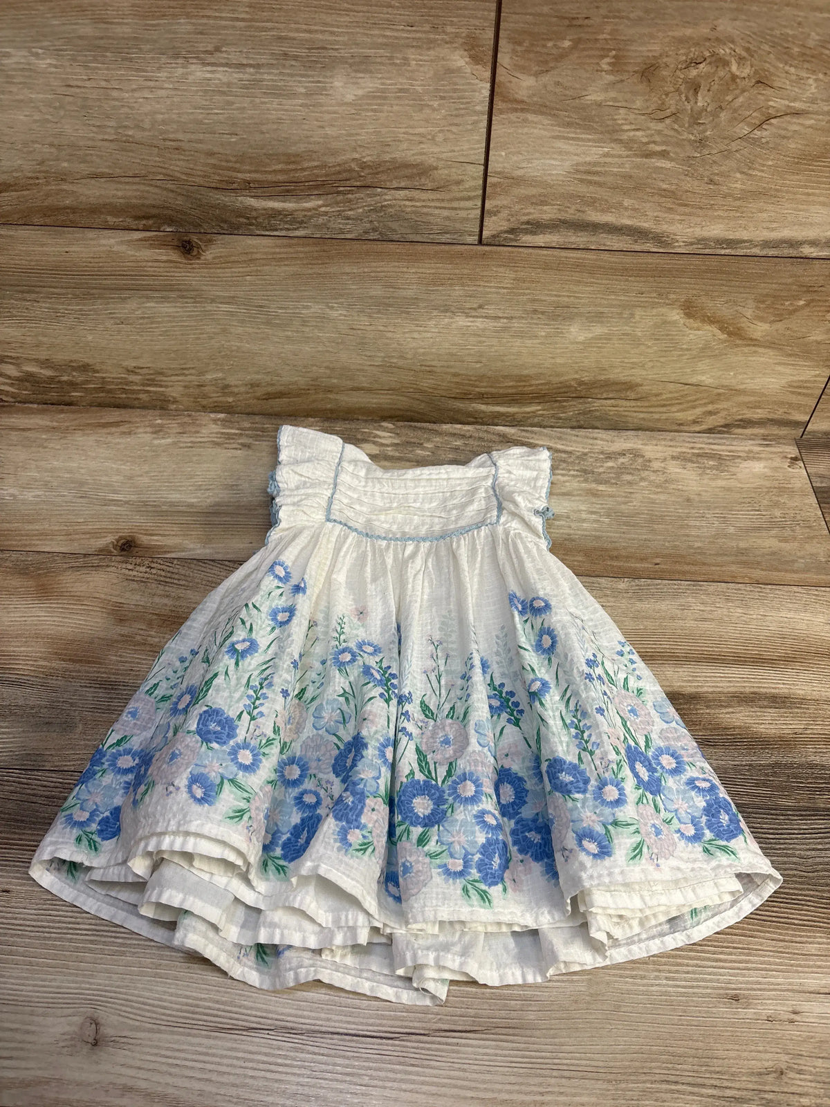 Haute Hippie white sleeveless dress for 18m baby with blue floral pattern on a wooden floor
